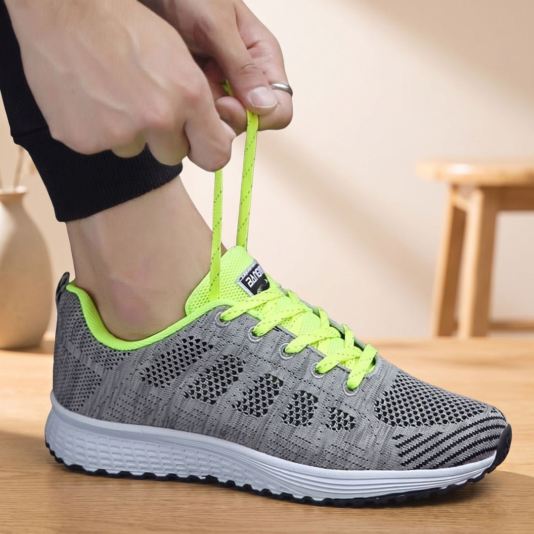 White lace-up mesh sneakers close-up showing cushioned sole and textured upper