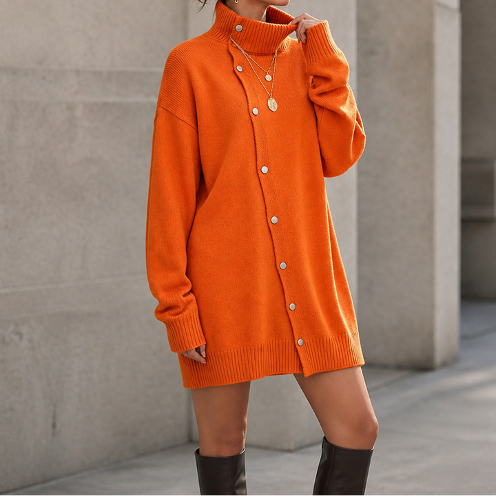Guinevere oversized turtleneck sweater dress styled with ankle boots, seated side view
