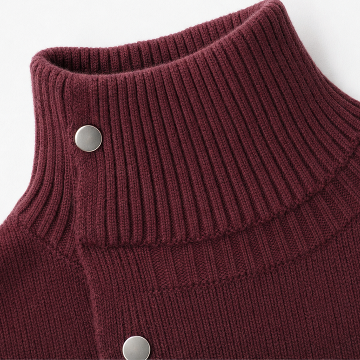 Guinevere oversized turtleneck sweater dress styled with ankle boots, seated side view