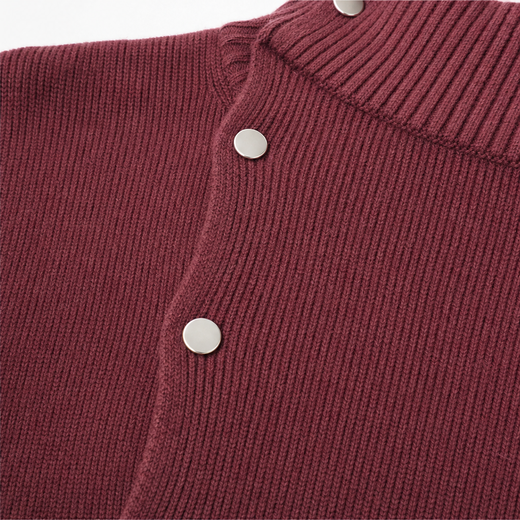 Guinevere oversized turtleneck sweater dress styled with ankle boots, seated side view