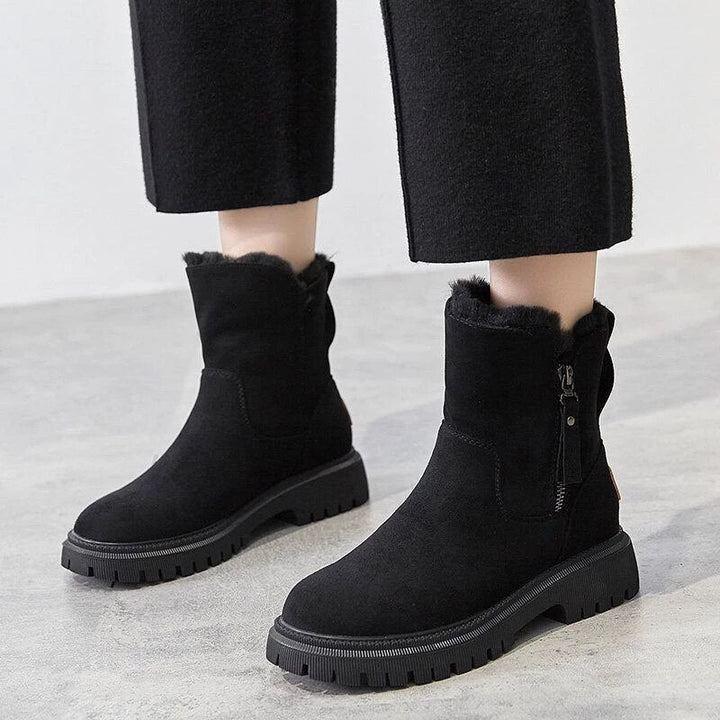 Marigold black ankle boots worn walking, side view