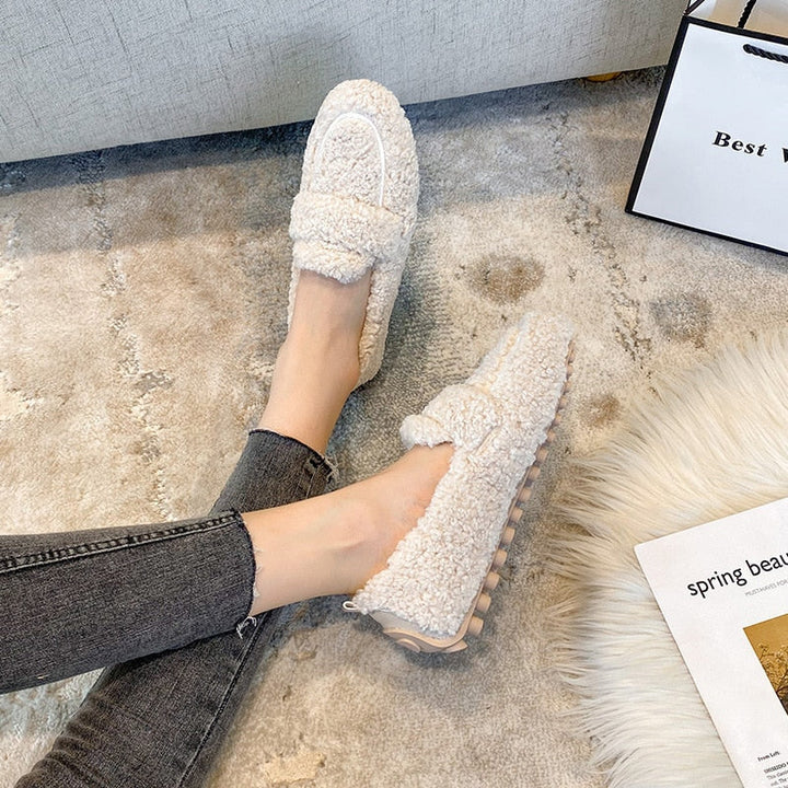 Wren plush platform slippers worn on feet, side view on rug