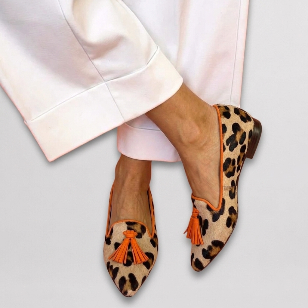 Marcelline orange leopard print pointed toe tassel loafers, close-up styled with white pants