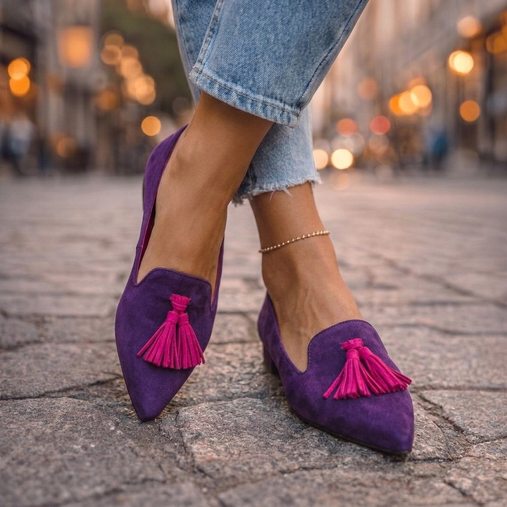 Marcelline tan tassel pointed toe loafers, side view on cobblestone street