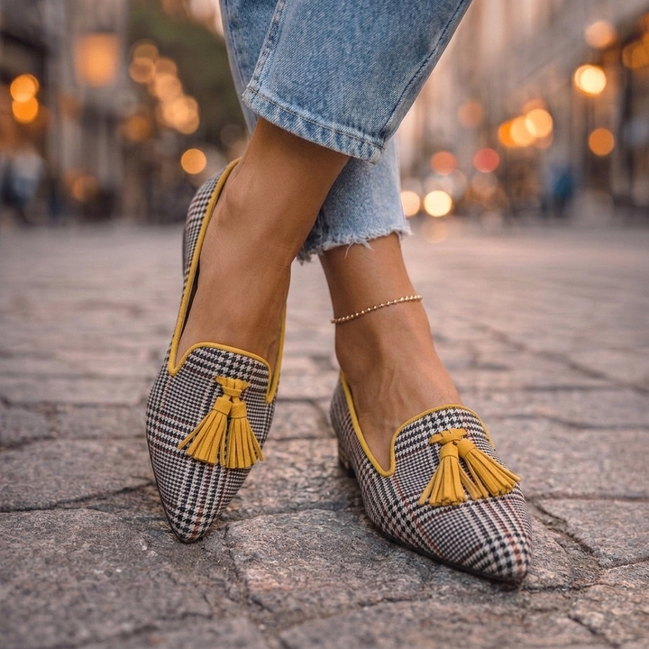 Marcelline tan tassel pointed toe loafers, side view on cobblestone street