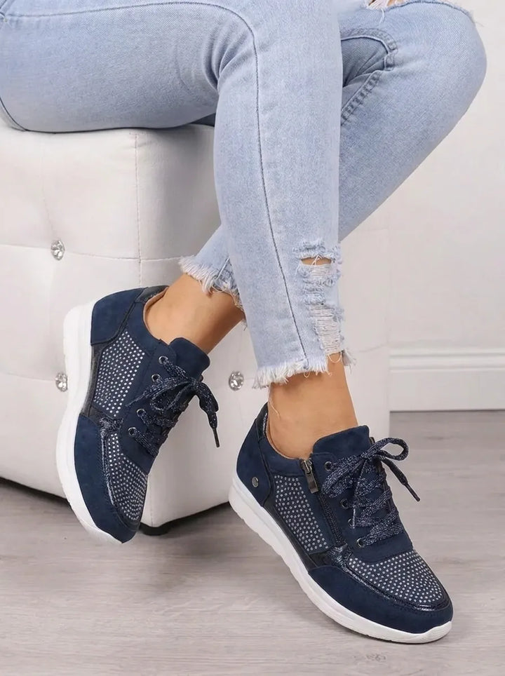 Marguerite sparkle sneakers, seated pose showing sole detail