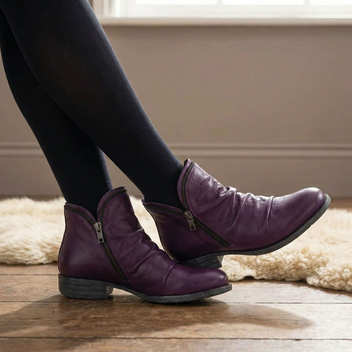 Marisol purple slouch ankle boots with side zip, worn crossed-leg close-up