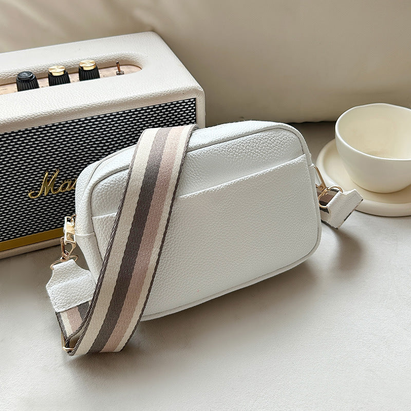 Vivienne white leather crossbody bag with striped strap, side view