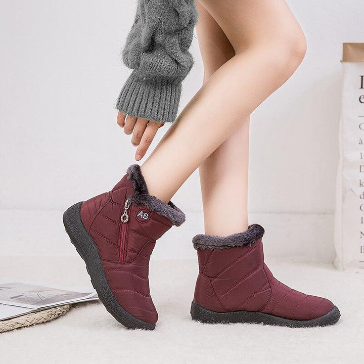 Marcelline brown ankle snow boots with fur collar, pair on flooring