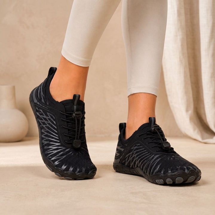 Marisela wide toe box walking sneakers in black, worn on feet, side view